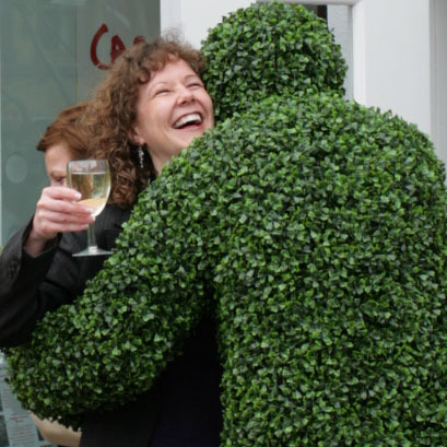 A Hedge Man giving a hug at a corporate reception in London