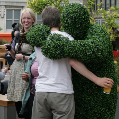 A Hedge Man giving a hug at an event in London