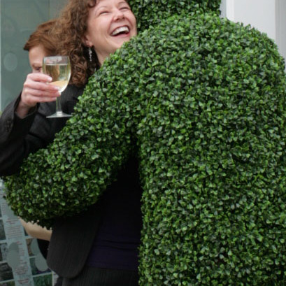 A Hedge Man giving a hug at a corporate reception in London.